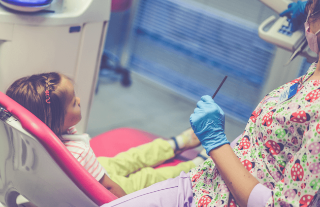 Dentist examining a young girl's teeth.