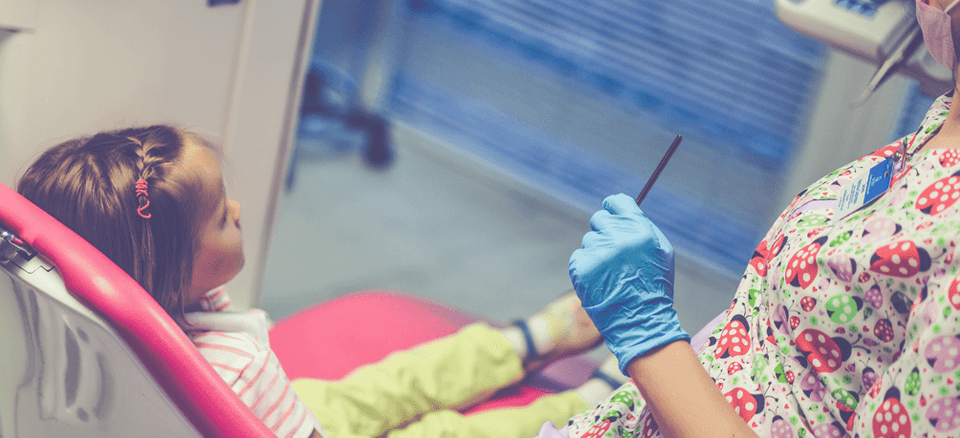 Dentist examining a young girl's teeth.