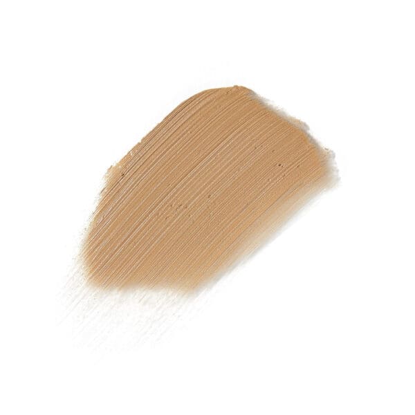 A close up of the bottom half of a brush with light brown liquid.